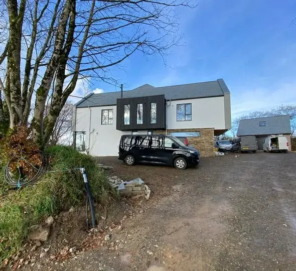 Large coastal family home finished in render with cladding and stone detail