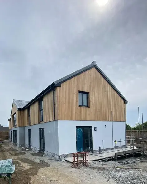 New build with white render and timber cladding to the gable